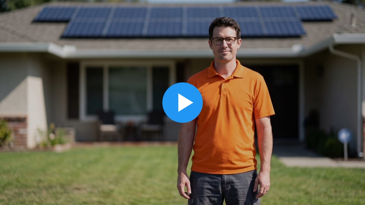 Eric, a solar company owner, on a lawn in front of a house with solar panels on the roof